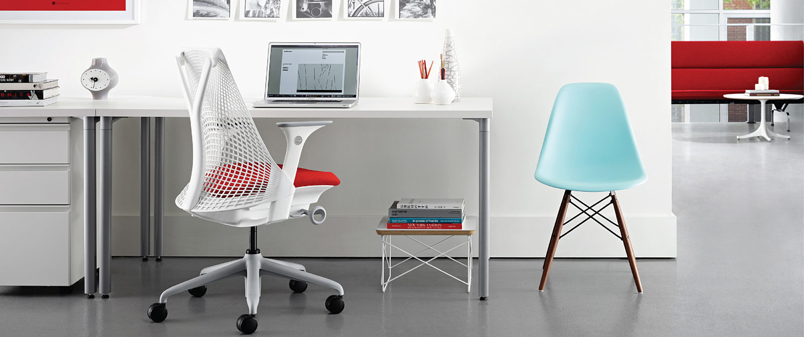 Individual workstation with ergonomic office chair and Eames molded plastic side chair.