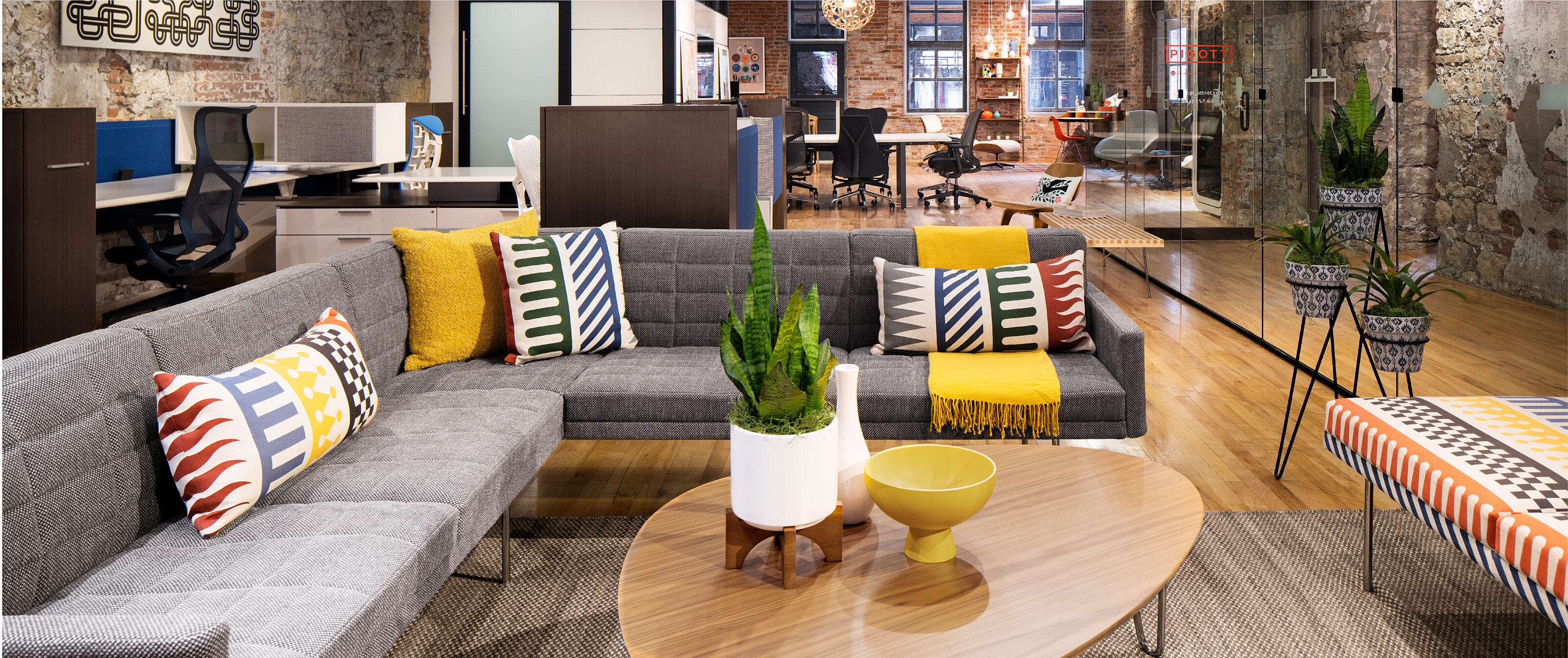 Modern office space featuring eclectic Maharam finishes, contemporary sofa, and greenery.