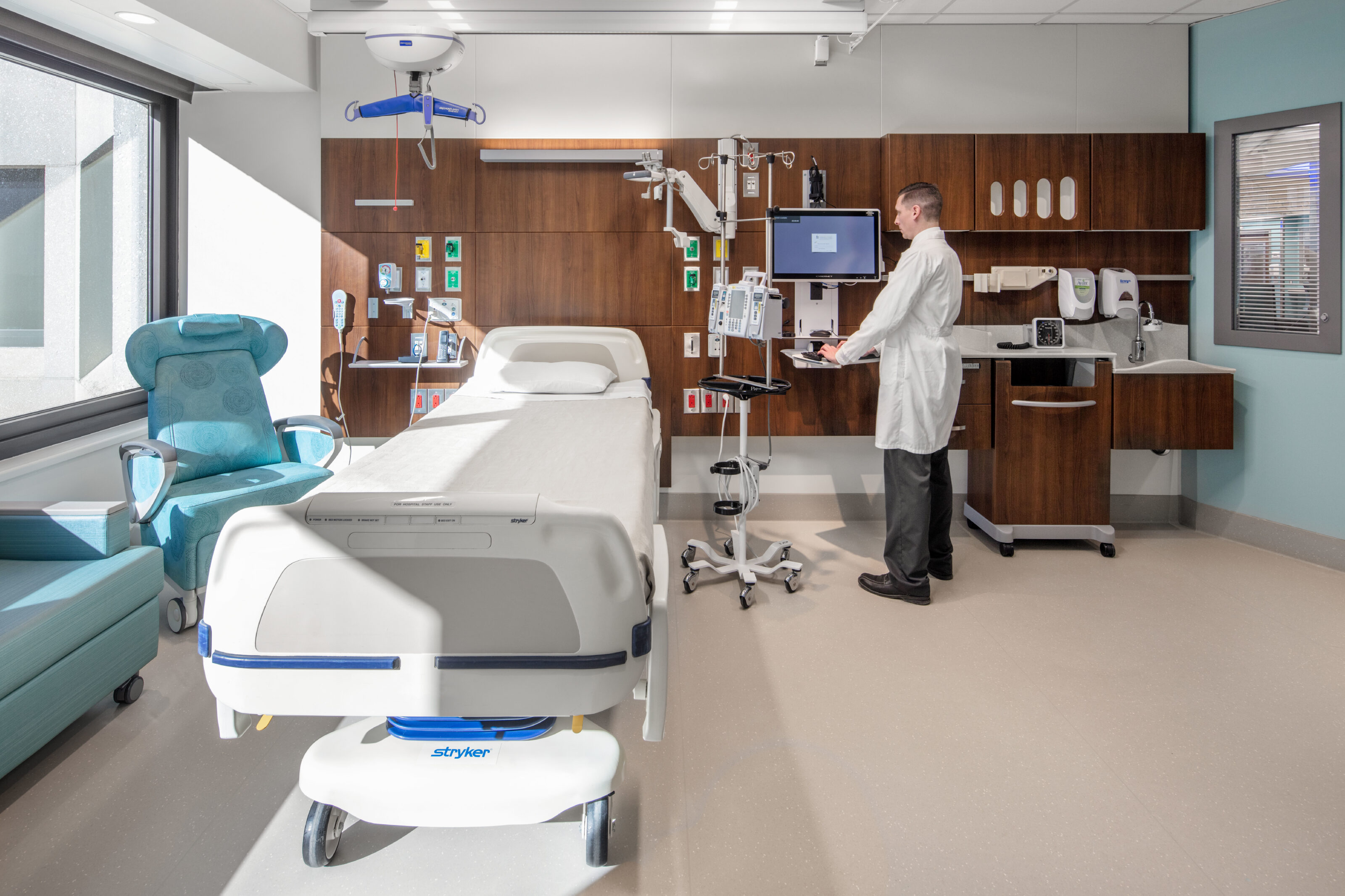 Patient room with patient seating and clinical casework.