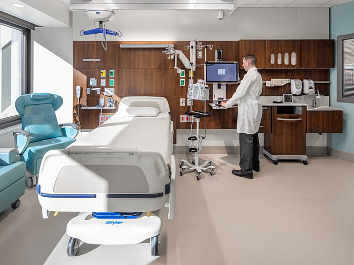 Patient room with patient seating and clinical casework.